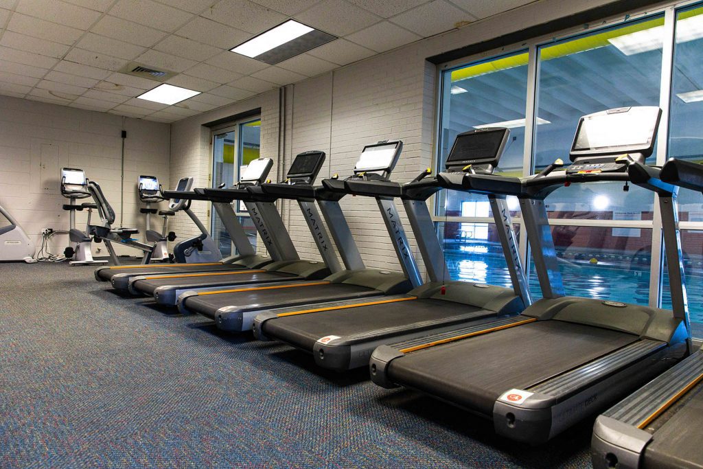 cardio area of the fitness center at greatplay overlooking the indoor swimming pool