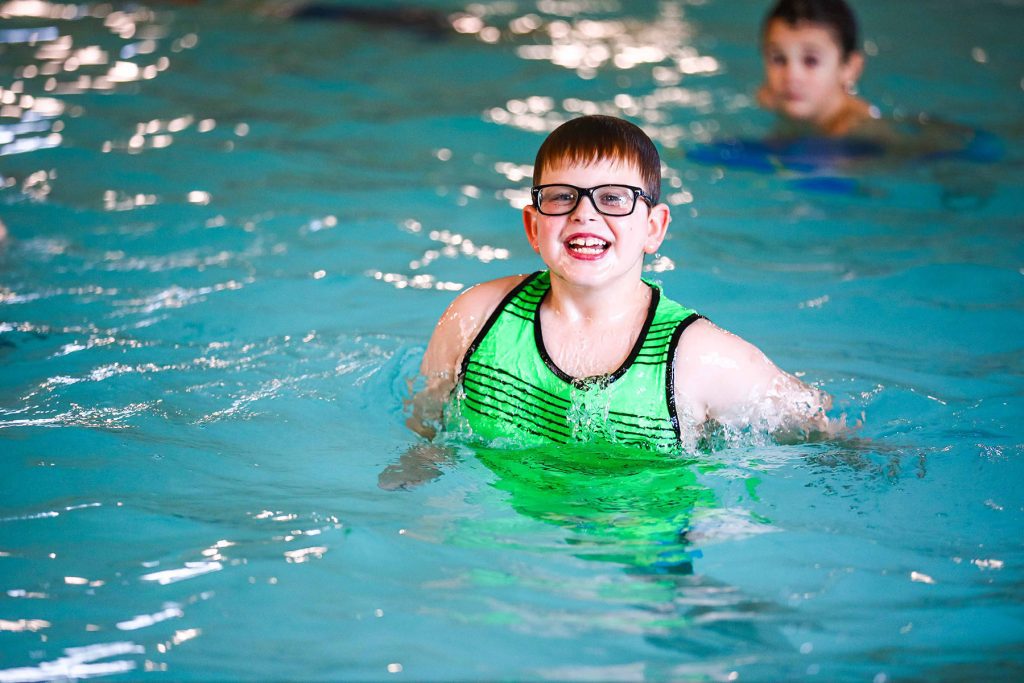 A boy swimming and having fun in a pool at GreatPLAY camps